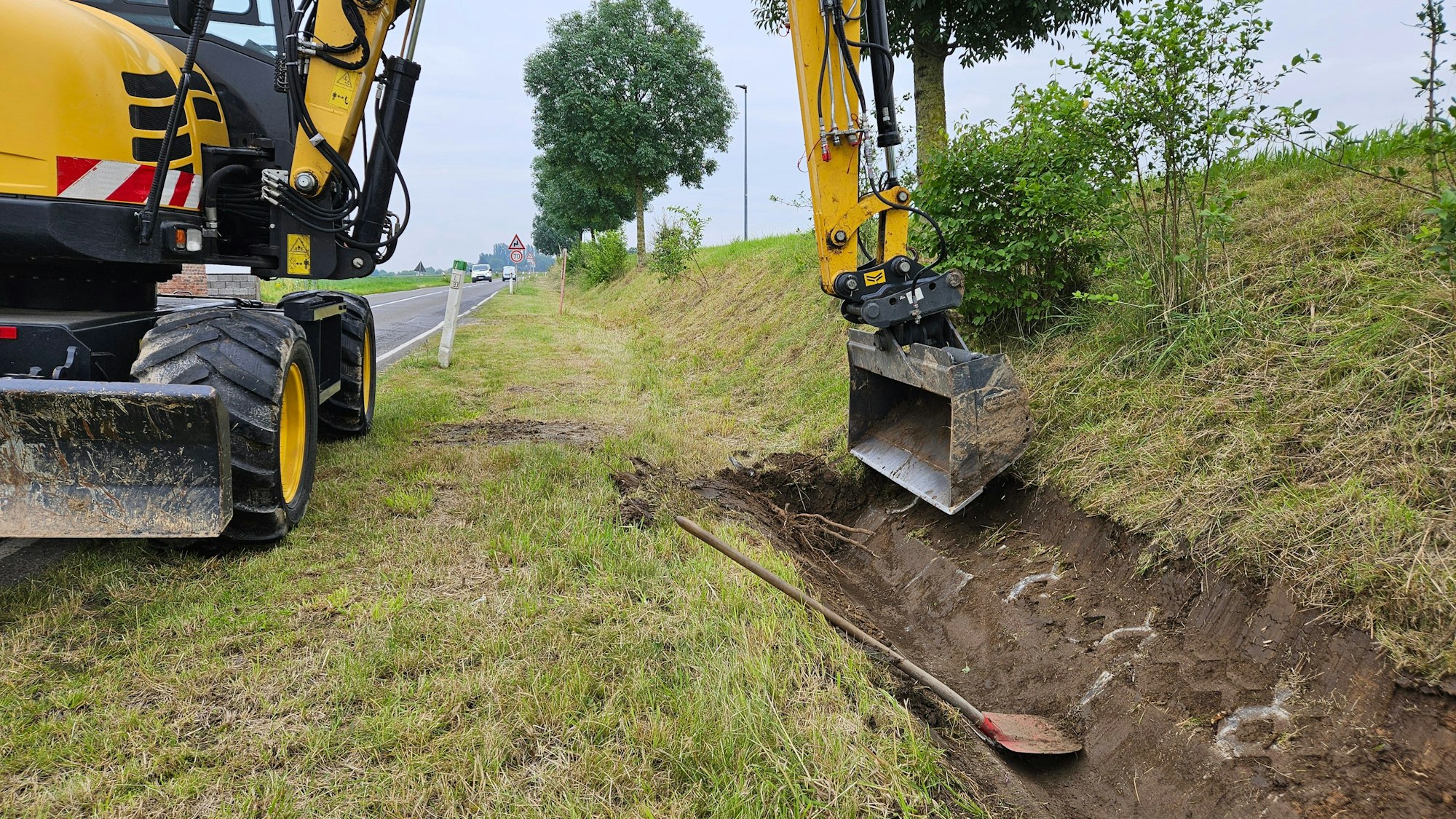 Ein Bagger legt einen Graben frei.