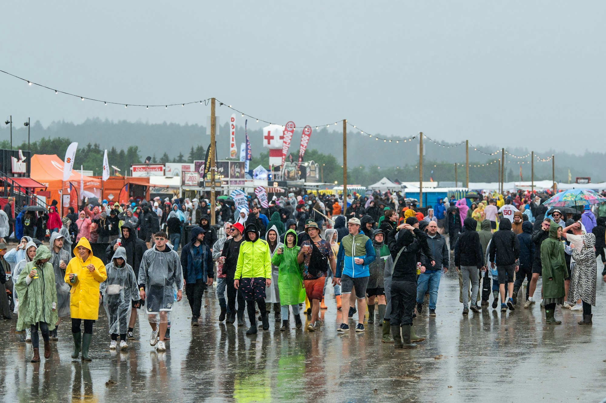 Festivalbesucher des Southside Festivals kämpfen mit Regencapes gegen den Regen an. Das Rockmusik-Festival gehört zu den größten deutschen Open-Air-Festivals.