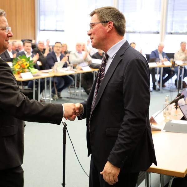 Landrat Stephan Santelmann gibt dem neuen Kreisdirektor Markus Fischer die Hand vor dem Kreistag.
