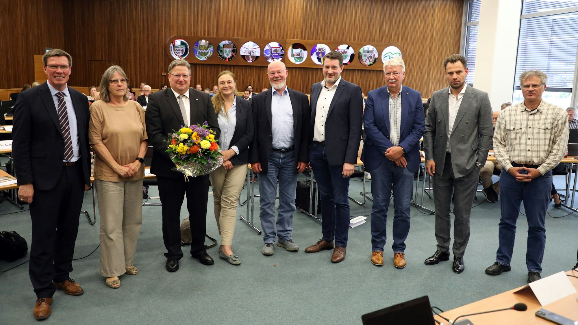 Der neue Kreisdirektor Markus Fischer steht mit Landrat Stephan Santelmann und Fraktions- und Gruppenvorsitzenden des Kreistags im großen Sitzungssaal des Kreishauses Am Rübezahlwald.