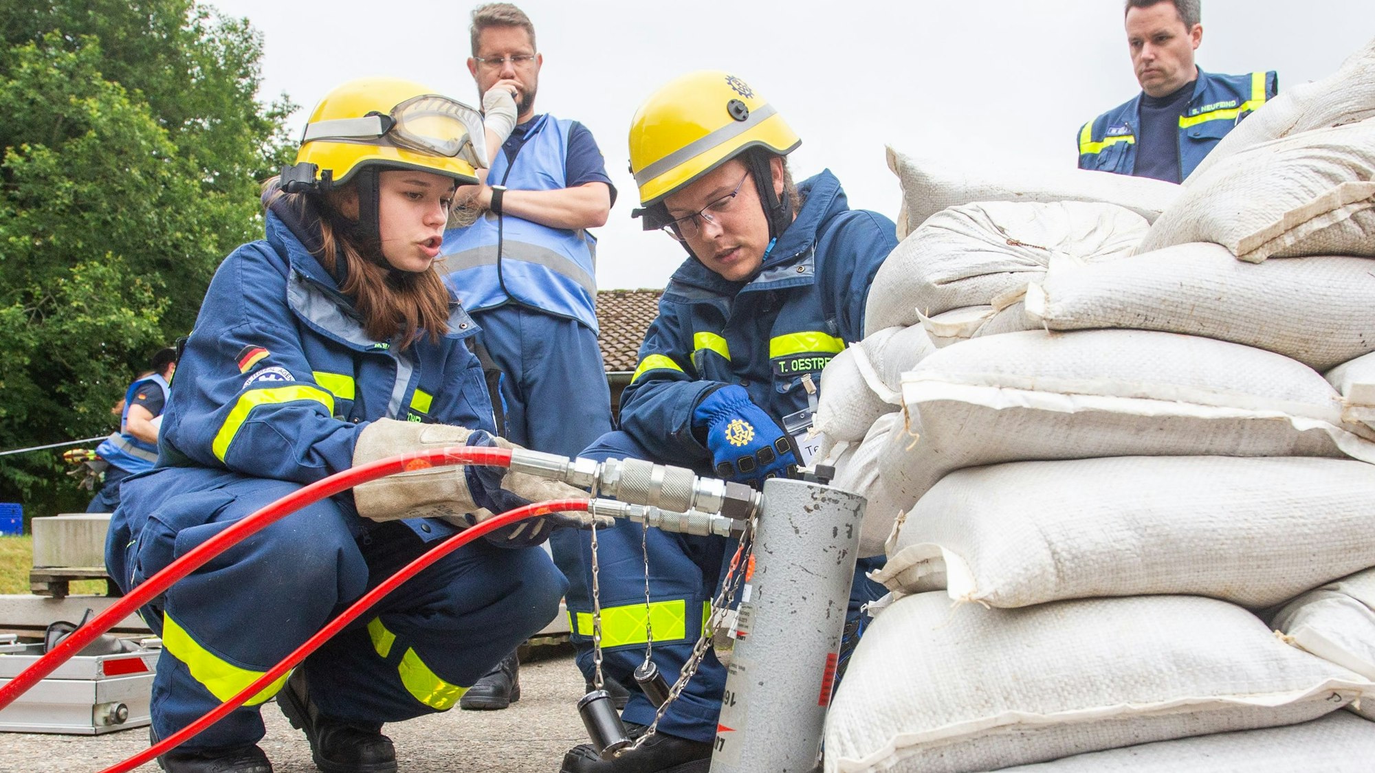 Das Foto zeigt Kräfte des THW an einem Wall aus Sandsäcken.