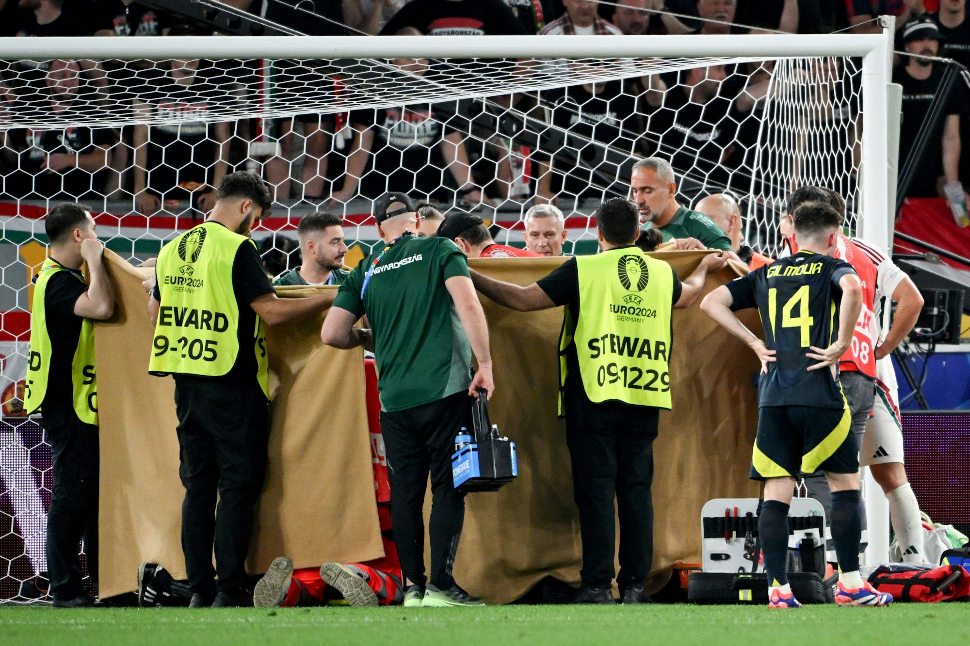 23.06.2024, Baden-Württemberg, Stuttgart: Fußball, UEFA Euro 2024, EM, Schottland - Ungarn, Vorrunde, Gruppe A, Spieltag 3, Stuttgart Arena, Nach einem Zusammenprall wird Ungarns Barnabas Varga hinter Sichtdecken behandelt. Foto: Marijan Murat/dpa +++ dpa-Bildfunk +++