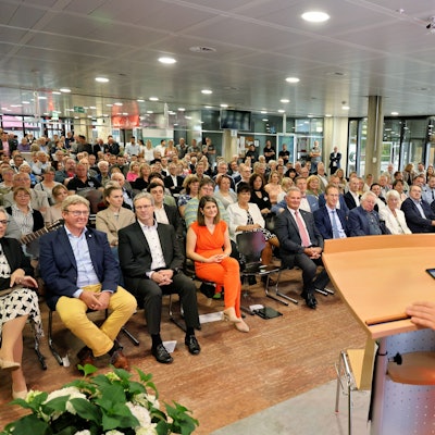 Landrat Markus Ramers steht an einem Pult und spricht zu einem großen Publikum.