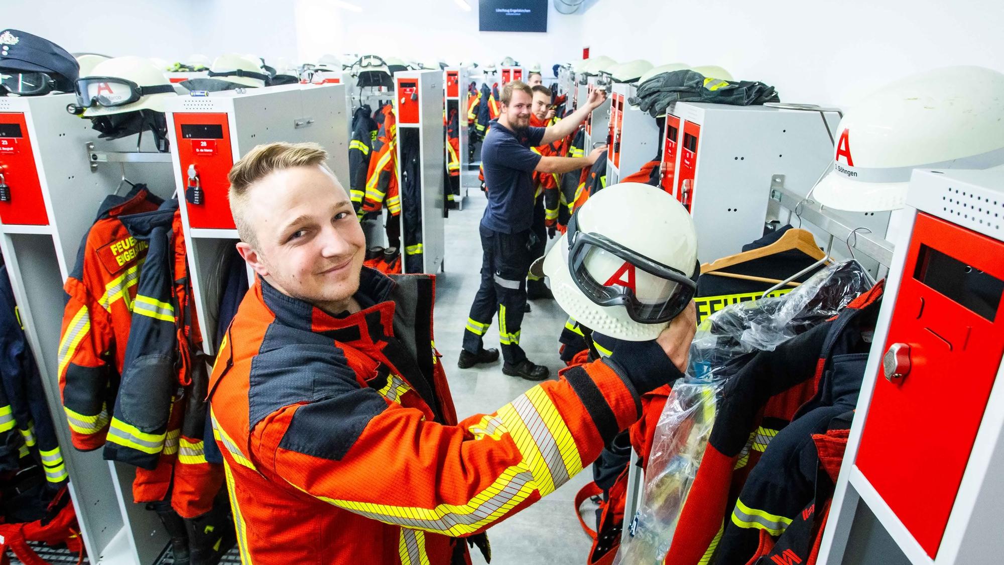 Das Foto zeigt Feuerwehrleute in der Umkleide der Feuerwache.