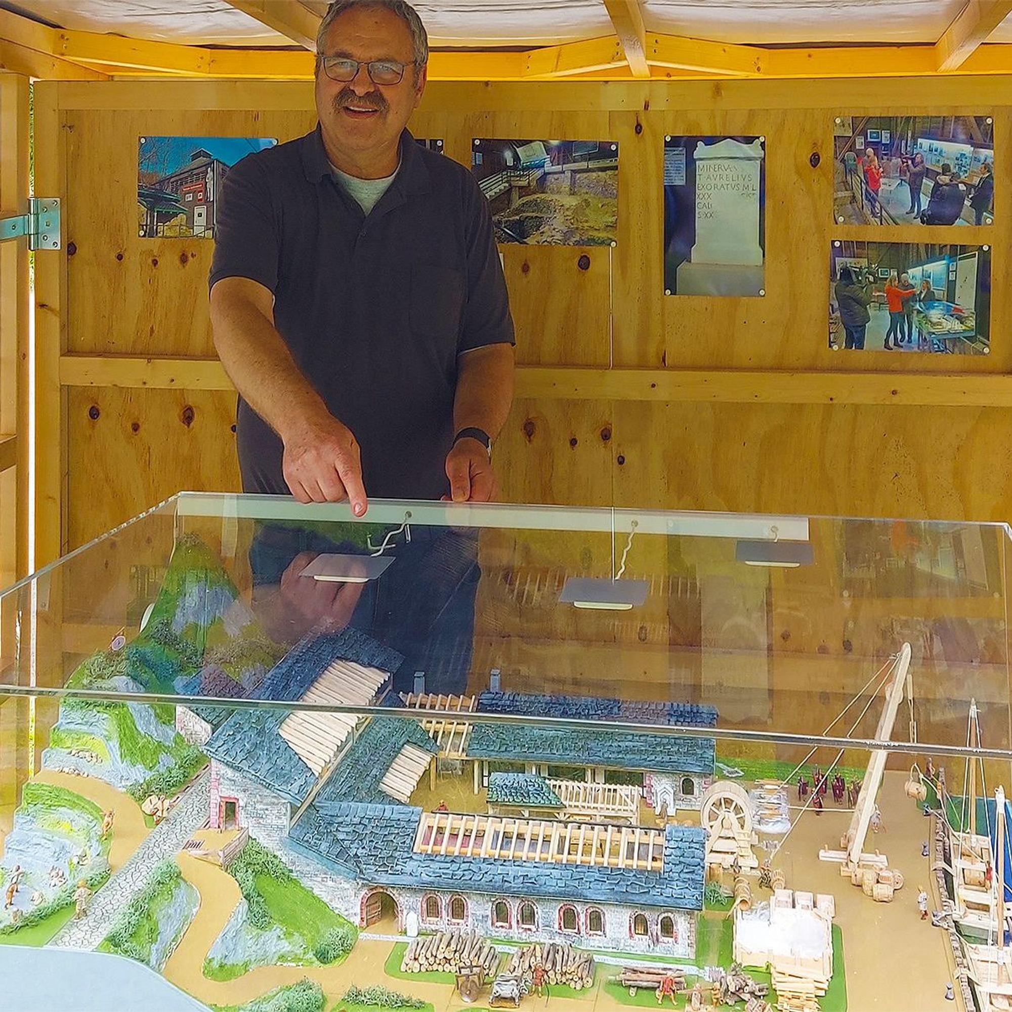 Harald Musal an einer Vitrine, in der sich ein Nachbau einer römischen Kalkbrennerei befindet.