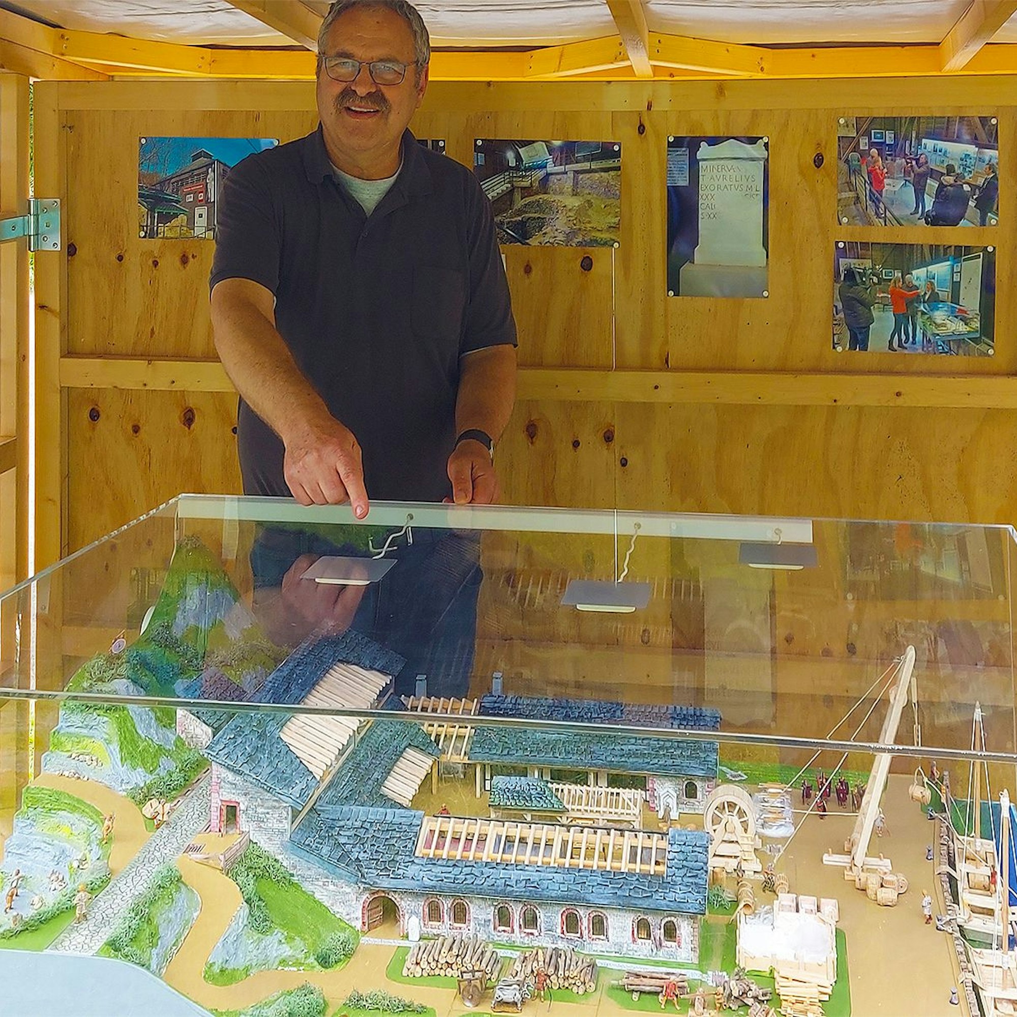 Harald Musal an einer Vitrine, in der sich ein Nachbau einer römischen Kalkbrennerei befindet.