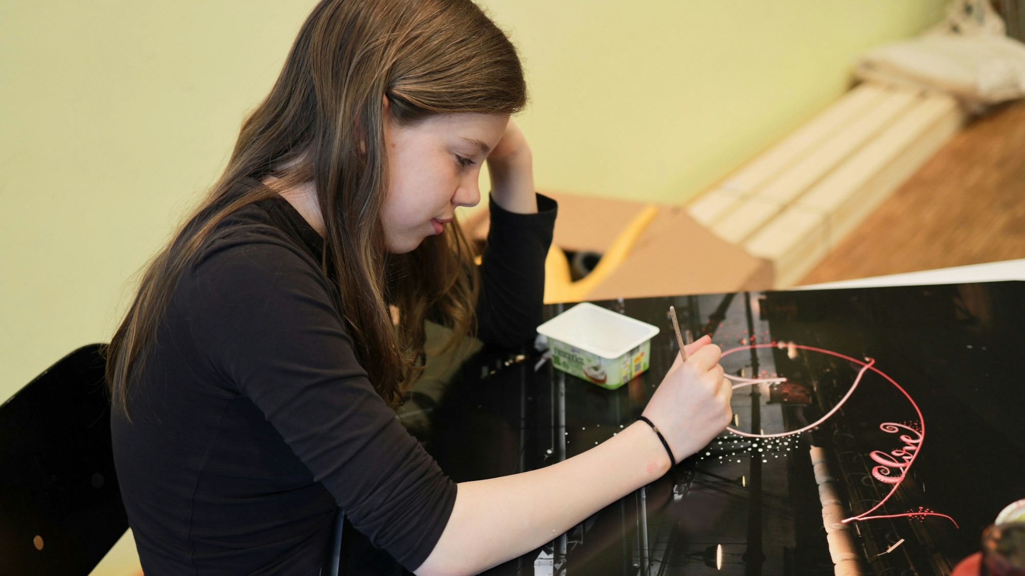 Schülerin Helene arbeitet an einer schwarzen Platte mit sogenannter „Lichtkunst“.