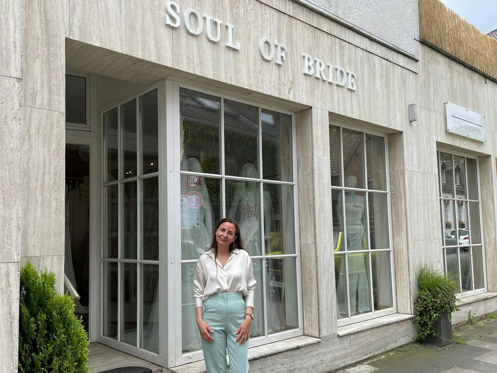 Besitzerin Kseniya Reyda steht vor dem Schaufenster ihres neuen Brautmodenladens