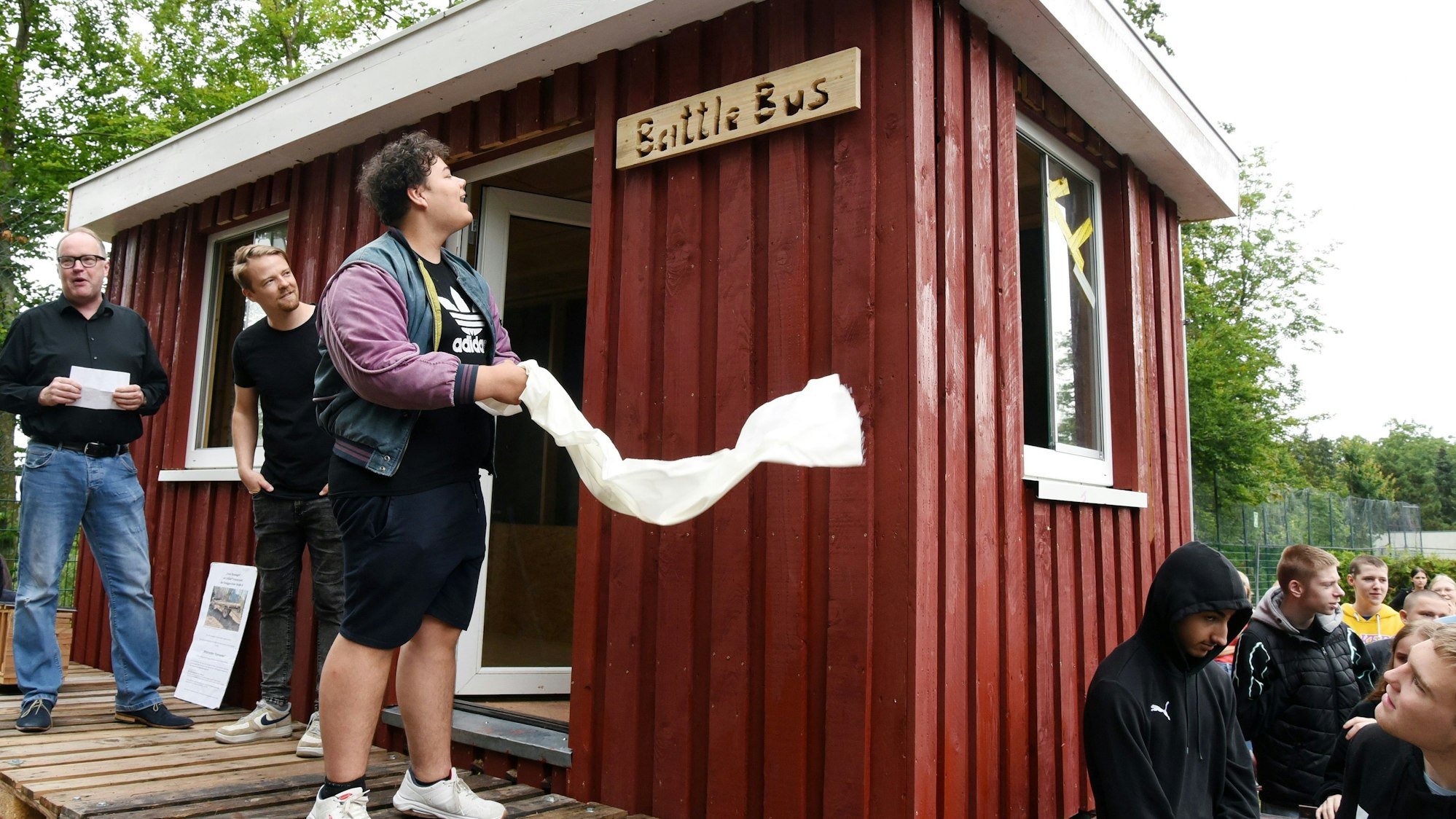 Schülerinnen und Schüler von der Roseggerschule in Waldbröl sowie deren Rektor Hinrich Schipper (links) weihen den neuen „Battle Bus“, einen neuen Platz zum Chillen, ein.