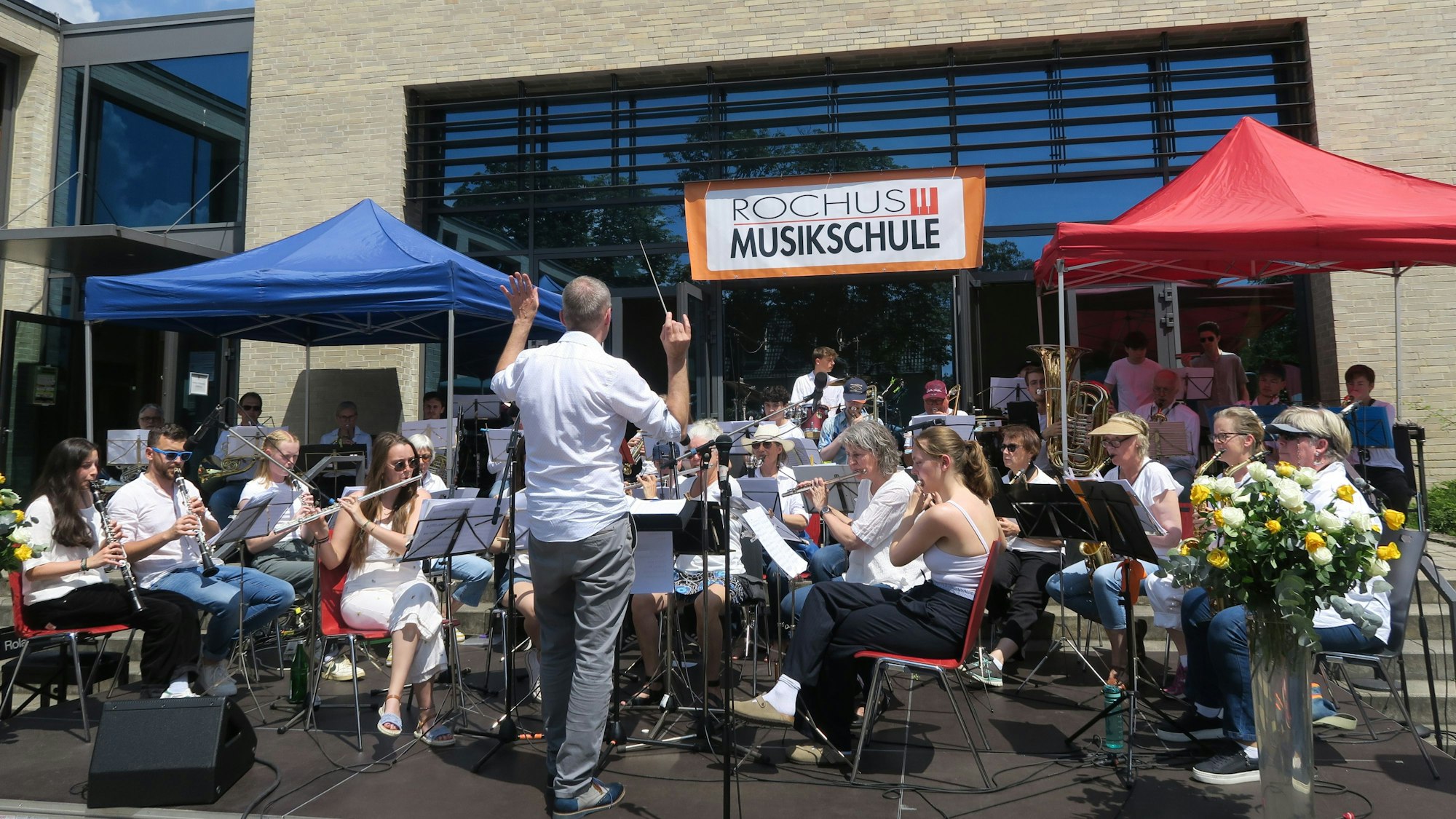 Das Blasorchester der Rochus-Musikschule unter Leitung von Norbert Krämer vor dem Bios Inn.