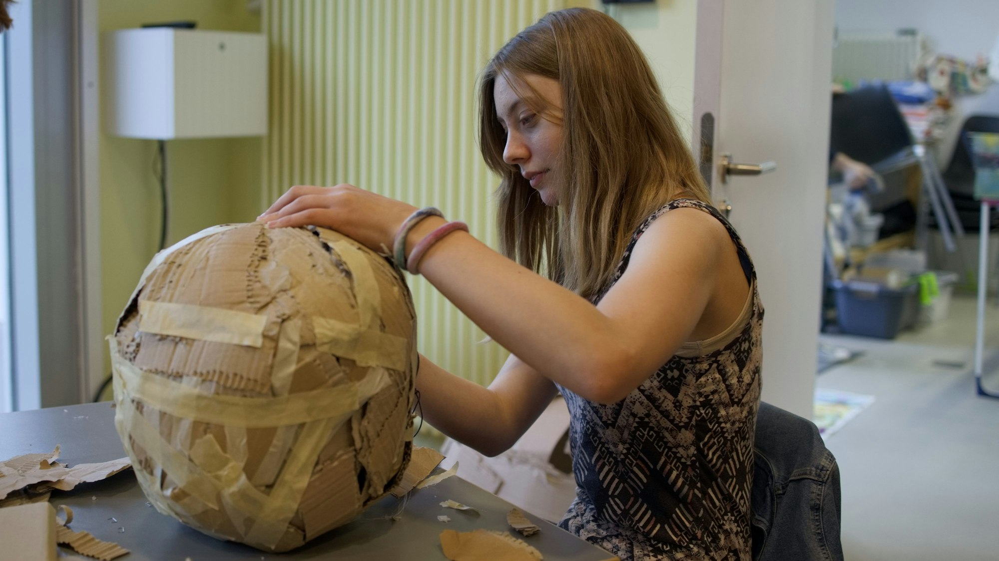 Mit Pappstücken formt Schülerin Sofia einen Ball.