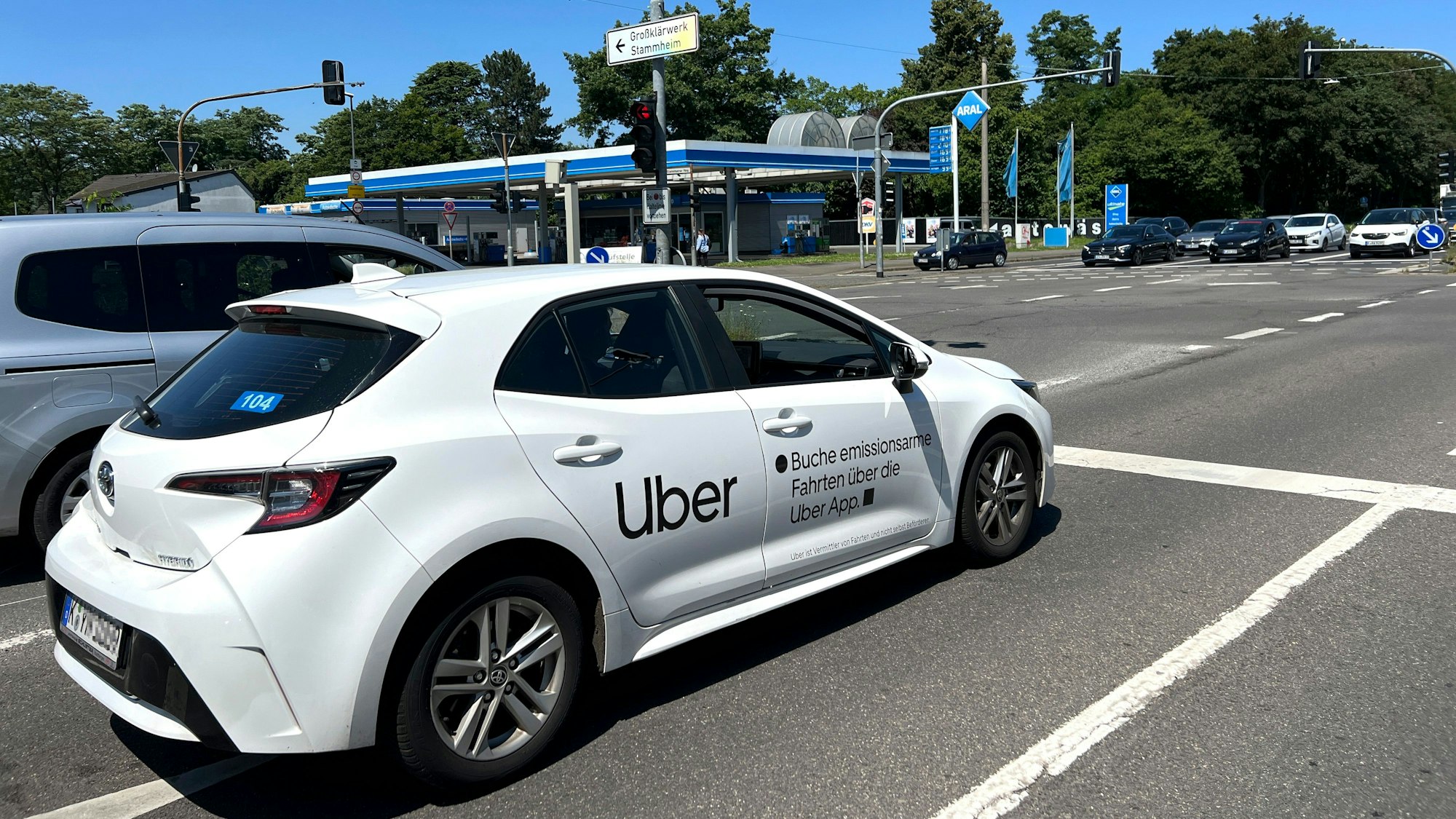 Ein Uber-Fahrzeug steht auf einer Straße an einer Ampel.