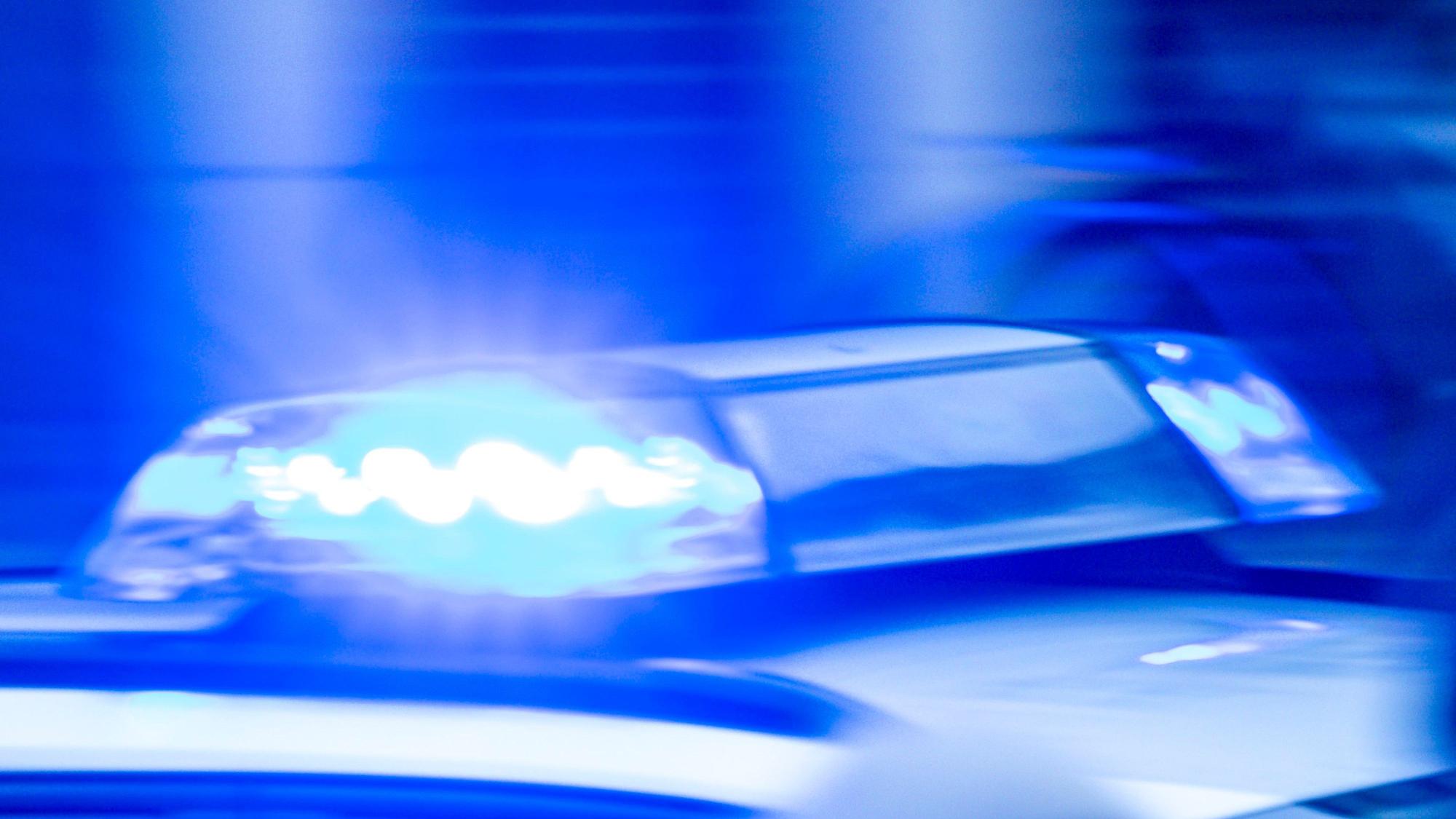 Ein Streifenwagen mit Blaulicht fährt in hoher Geschwindigkeit durch die Nacht. (Symbolbild)
