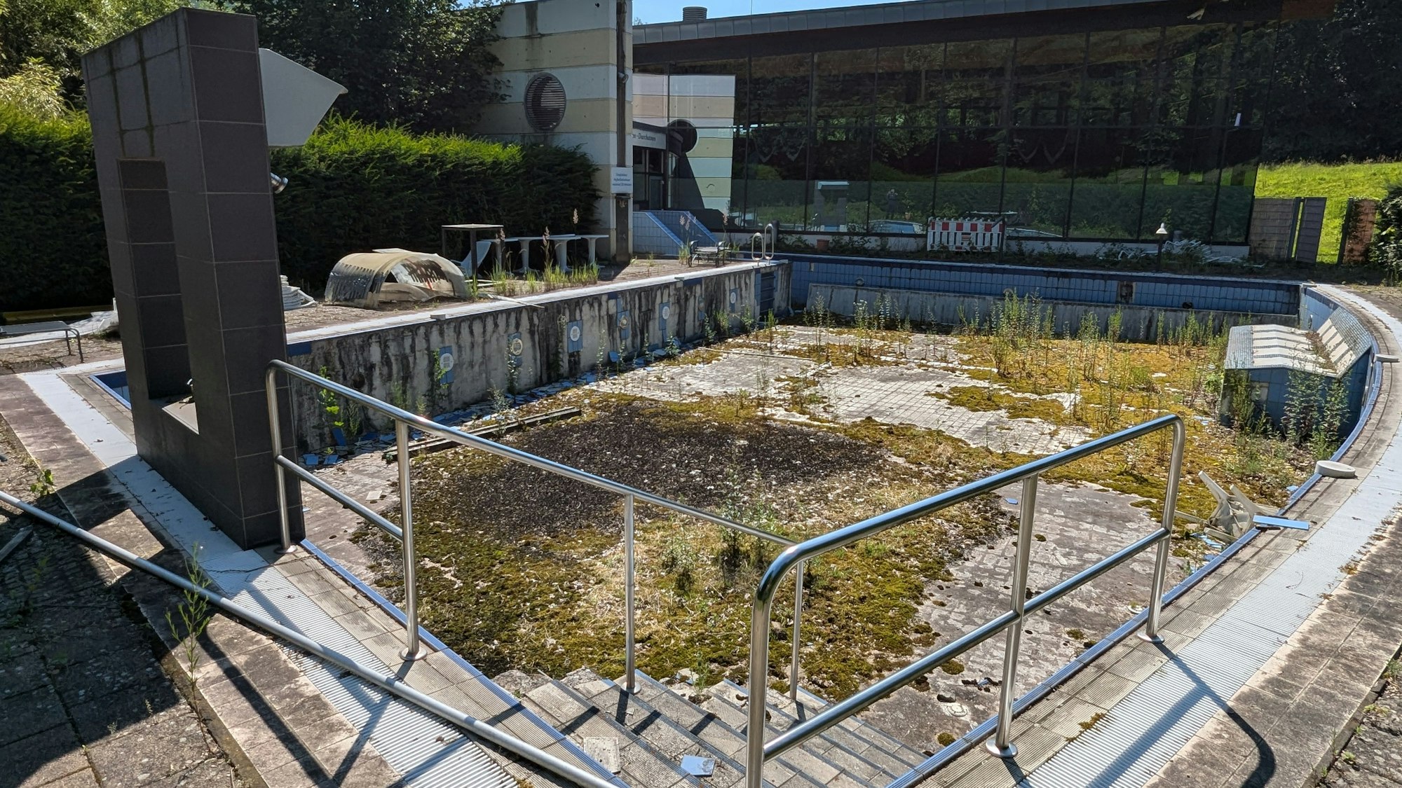 Das Foto zeigt das leere Solebecken hinter dem Familienbad De Bütt, das seit über zehn Jahren verfällt.