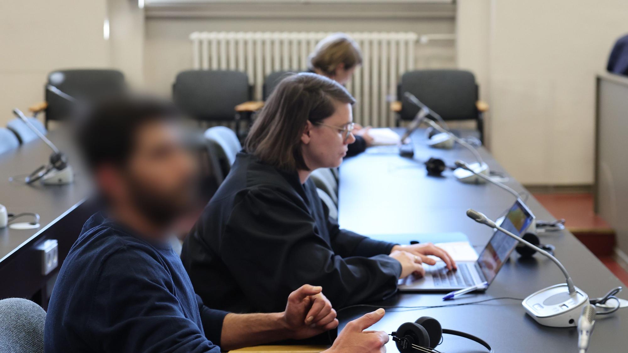 Der Angeklagte und seine Rechtsanwältin Anna Carlotta Bloch sitzen kurz vor Beginn der Verhandlung in einem Gerichtssaal des Strafjustizgebäudes in Hamburg.