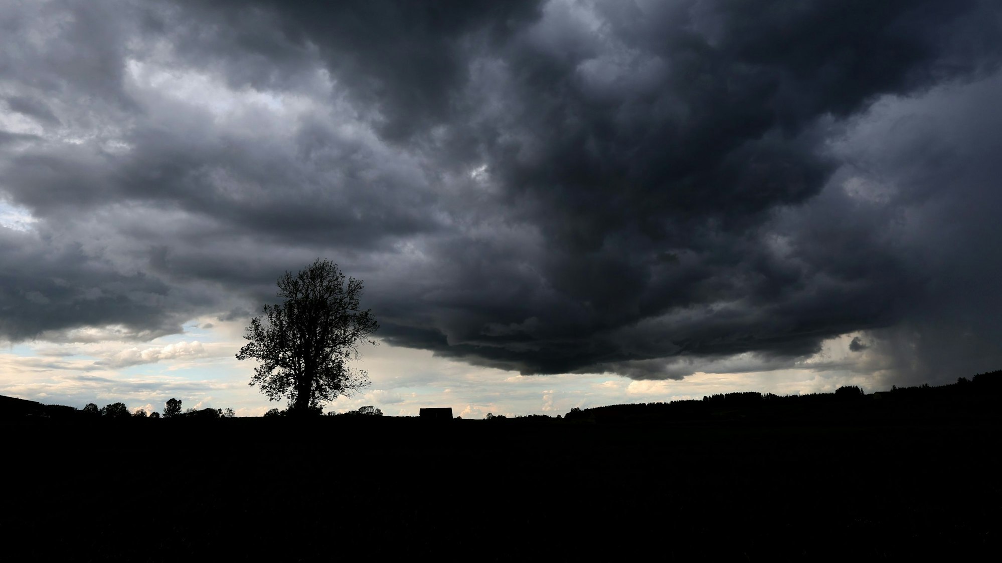 Eine dunkle Unwetterfront zieht am Himmel auf. In Köln und Region drohen spätestens ab Donnerstag Unwetter und Starkregen.(Symbolbild)