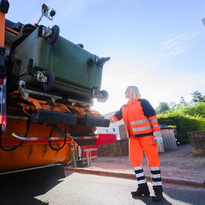 Eine Mülltonne wird geleert.