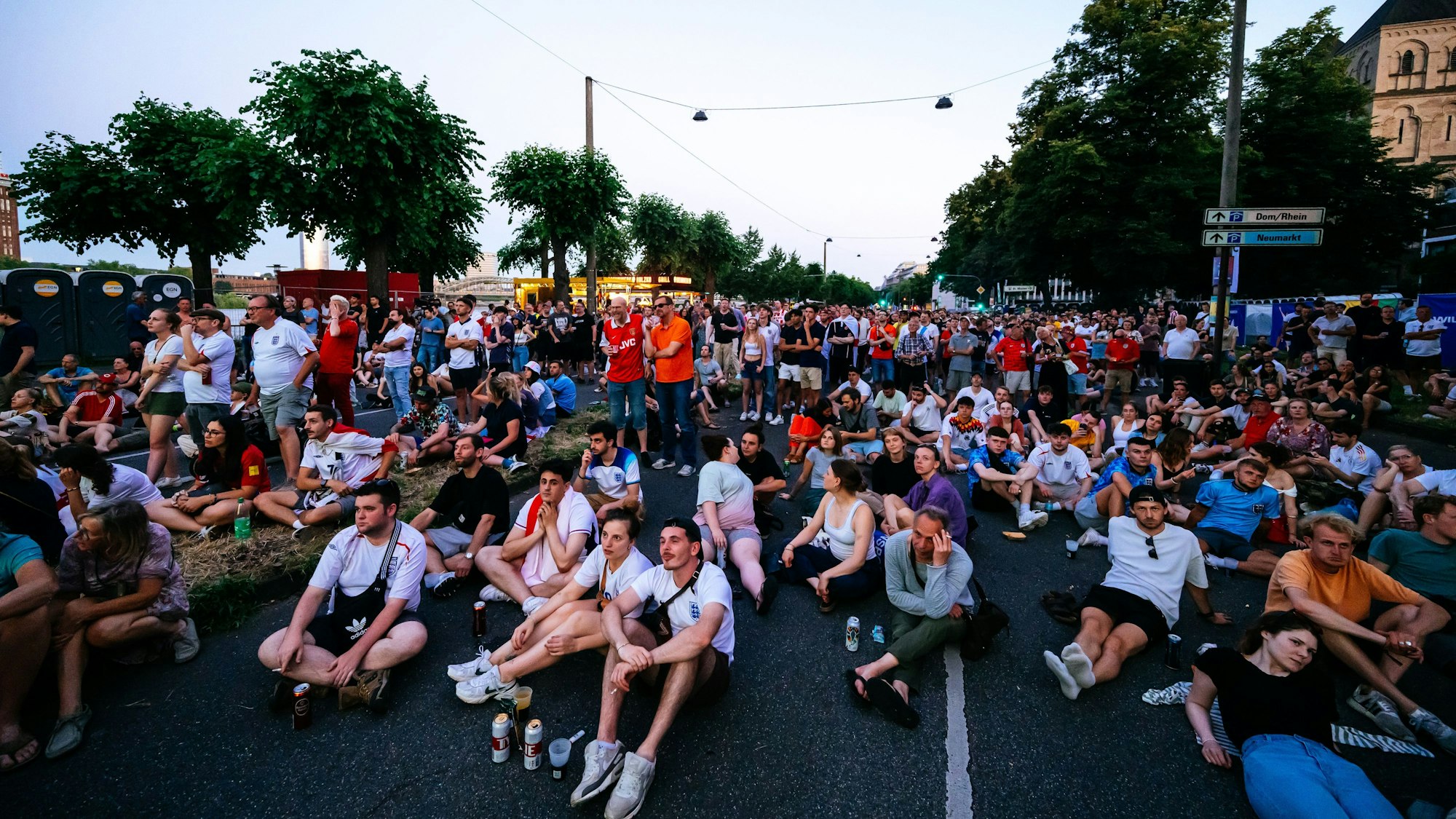 Ganz gemütlich: Fans schauen das England-Spiel auf der spärlich gefüllten Rheinuferstraße.