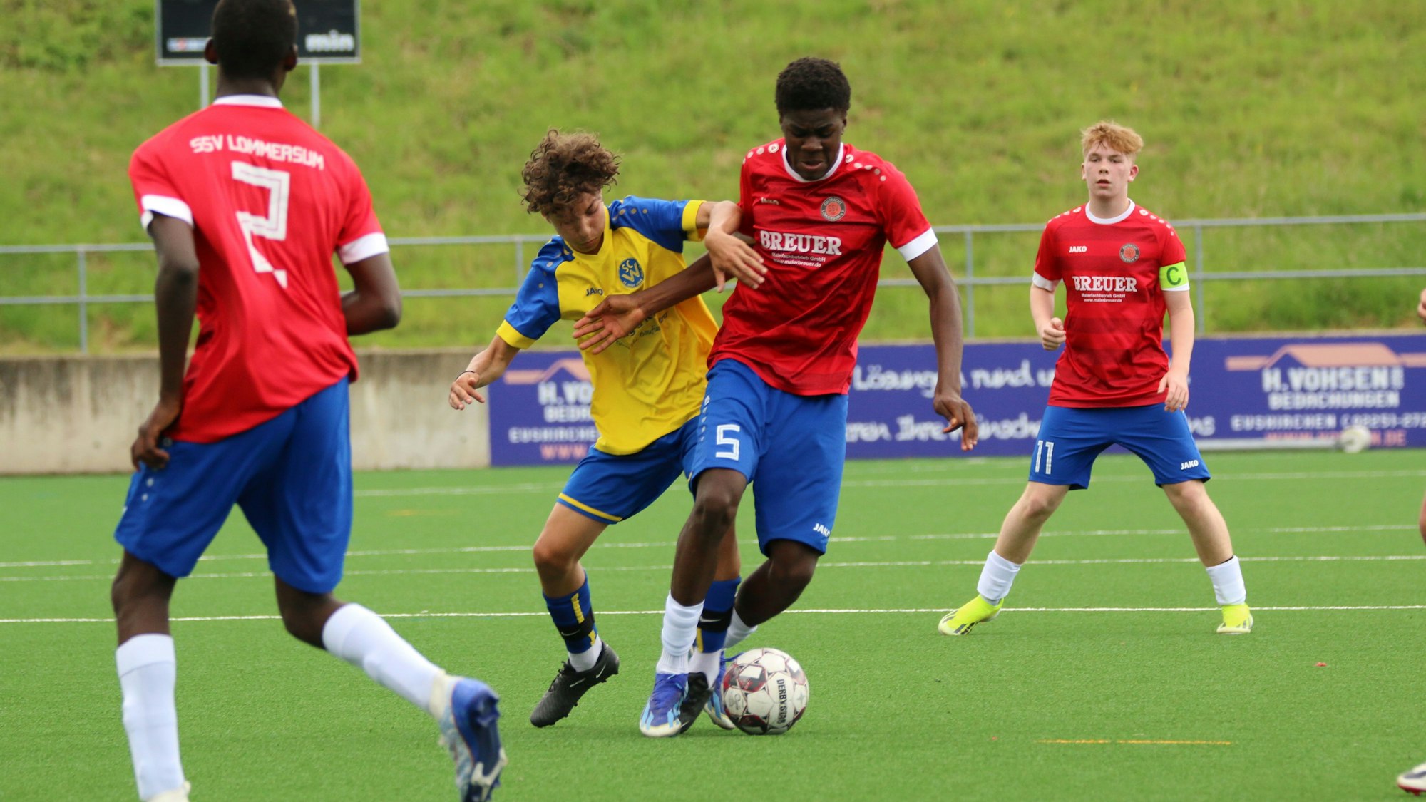 Ein Spieler des SC West Köln stört seinen Gegenspieler. Zwei Lommersumer schauen zu.