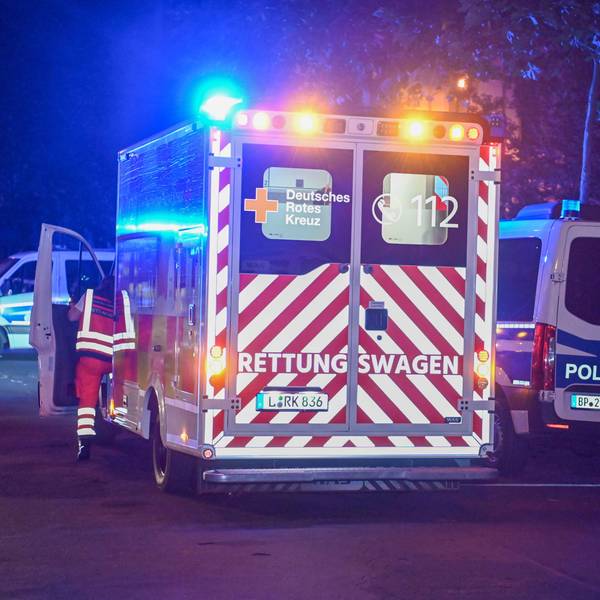 Ein Krankenwagen und ein Einsatzwagen der Polizei stehen mit Blaulicht auf einer Straße während eines Einsatzes. (Symbolbild)