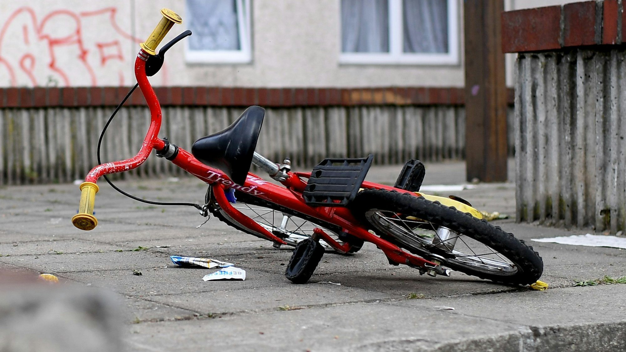Ein Kinderfahrrad liegt in einem Aufgang zu einem Plattenbau.