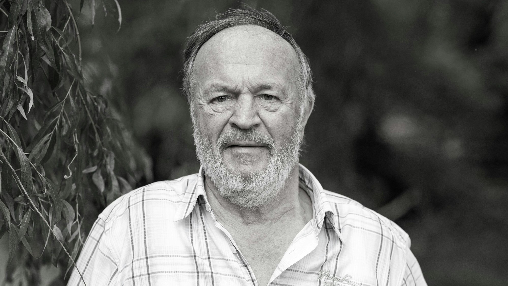 ARCHIV - 04.07.2022, Bayern, Pleiskirchen: Fredl Fesl, niederbayerischer Musiker und Sänger, steht an einem alten Anhänger unter einer Weide in seinem Garten.