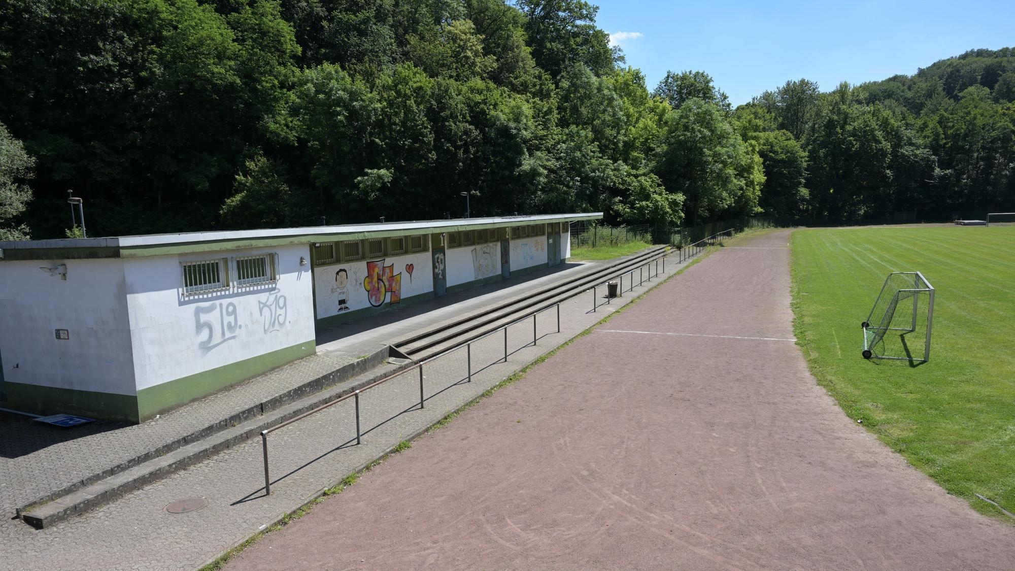 Laufbahn und alte Umkleidekabinen eines Sportplatzes.
