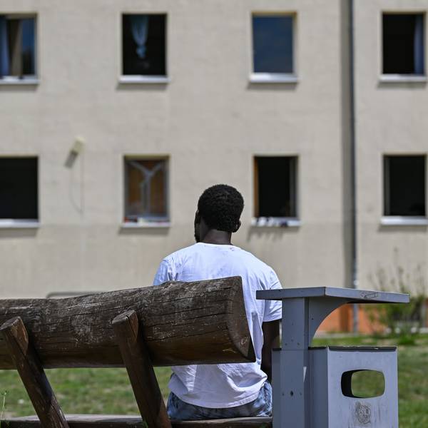Ein Migrant sitzt auf einer Bank auf dem Gelände der Zentralen Erstaufnahmeeinrichtung für Asylbewerber (ZABH) des Landes Brandenburg.