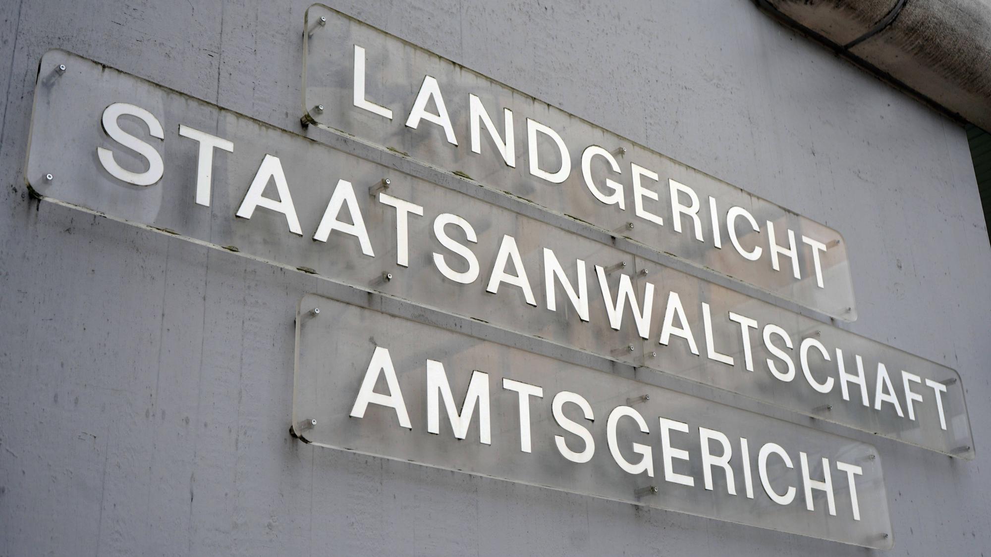 An einem Gebäudekomplex in der Innenstadt von Siegen hängen Schilder, die auf den Sitz des Amtsgerichts, Landgerichts und der Staatsanwaltschaft hinweisen. (Archivbild)