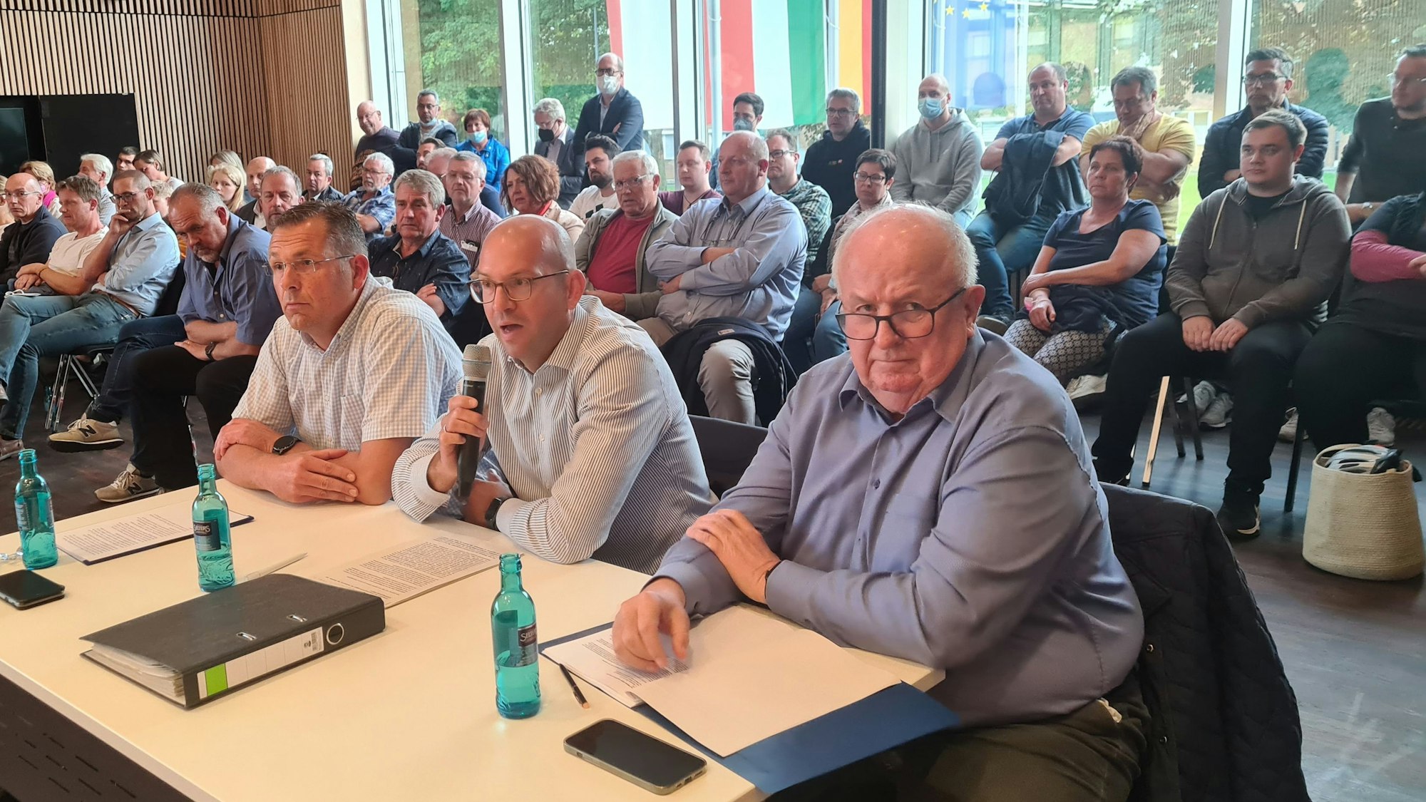 Menschen sitzen in einem großen Saal.