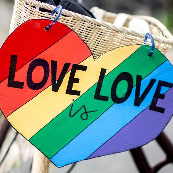 Ein herzförmiges Schild mit der Aufschrift "Love is Love" hängt im Rahmen des CSD (Christopher Street Day) am Fahrrad einer Teilnehmerin.
