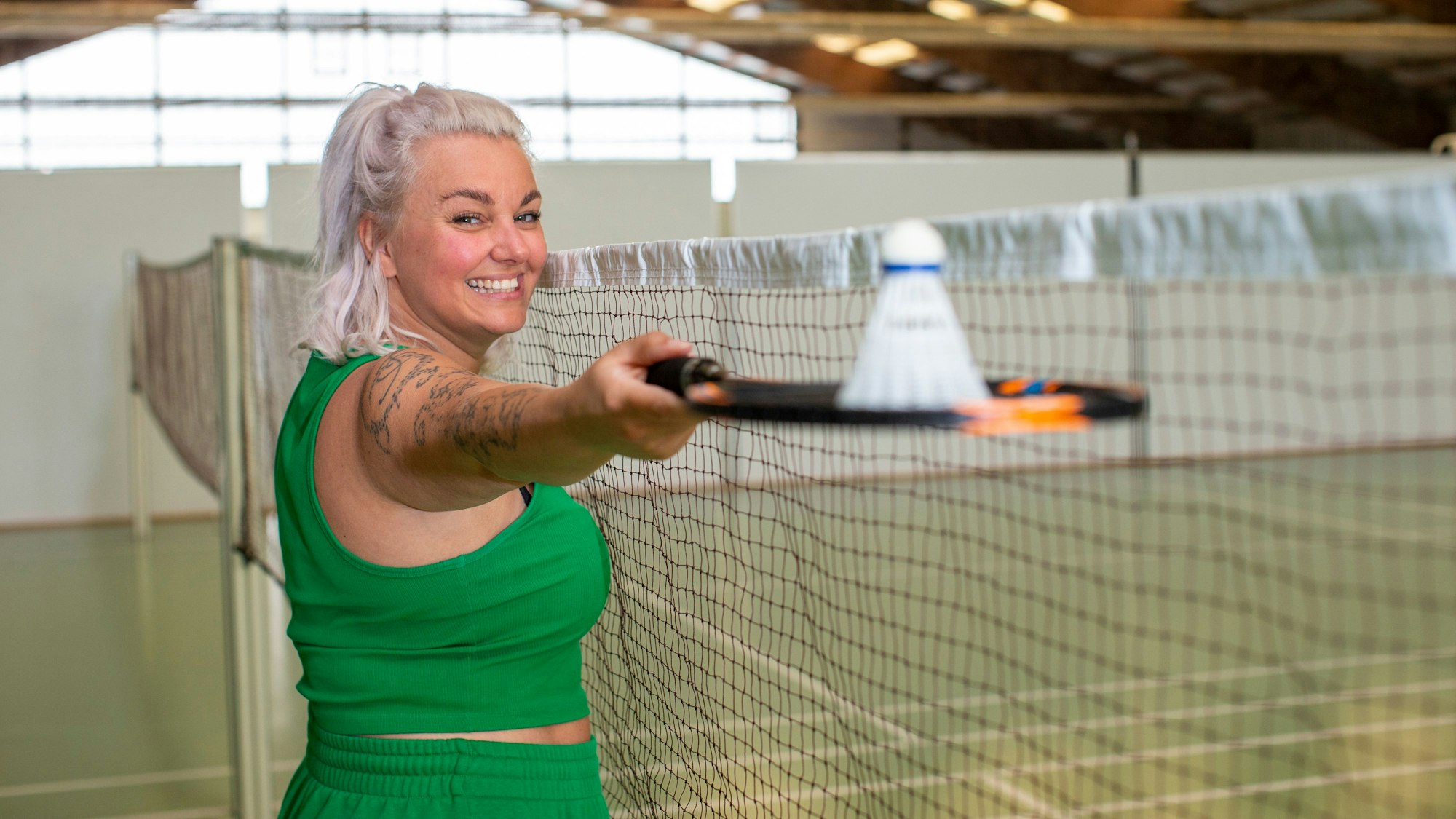 Nici Kempermann steht in der Badminton-Halle des Sportcenter Kautz mit einem Badminton-Schläger in der Hand.
