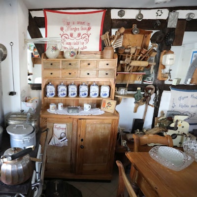 Eine Küche mit altem Holzofen, Töpfen und Schränken.