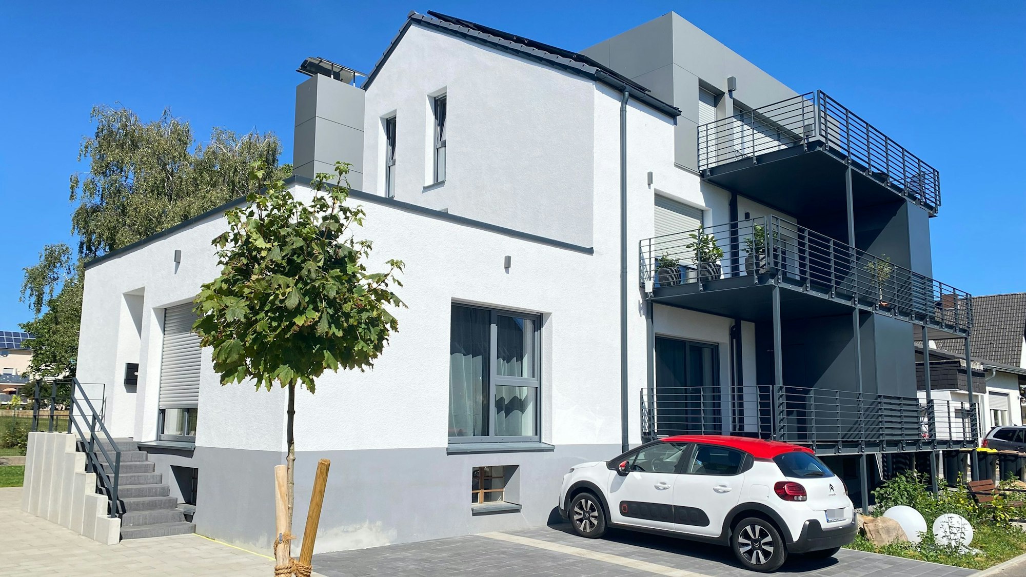 Das Bild zeigt ein Haus mit mehreren Balkonen, optisch auf dem neuesten Stand.