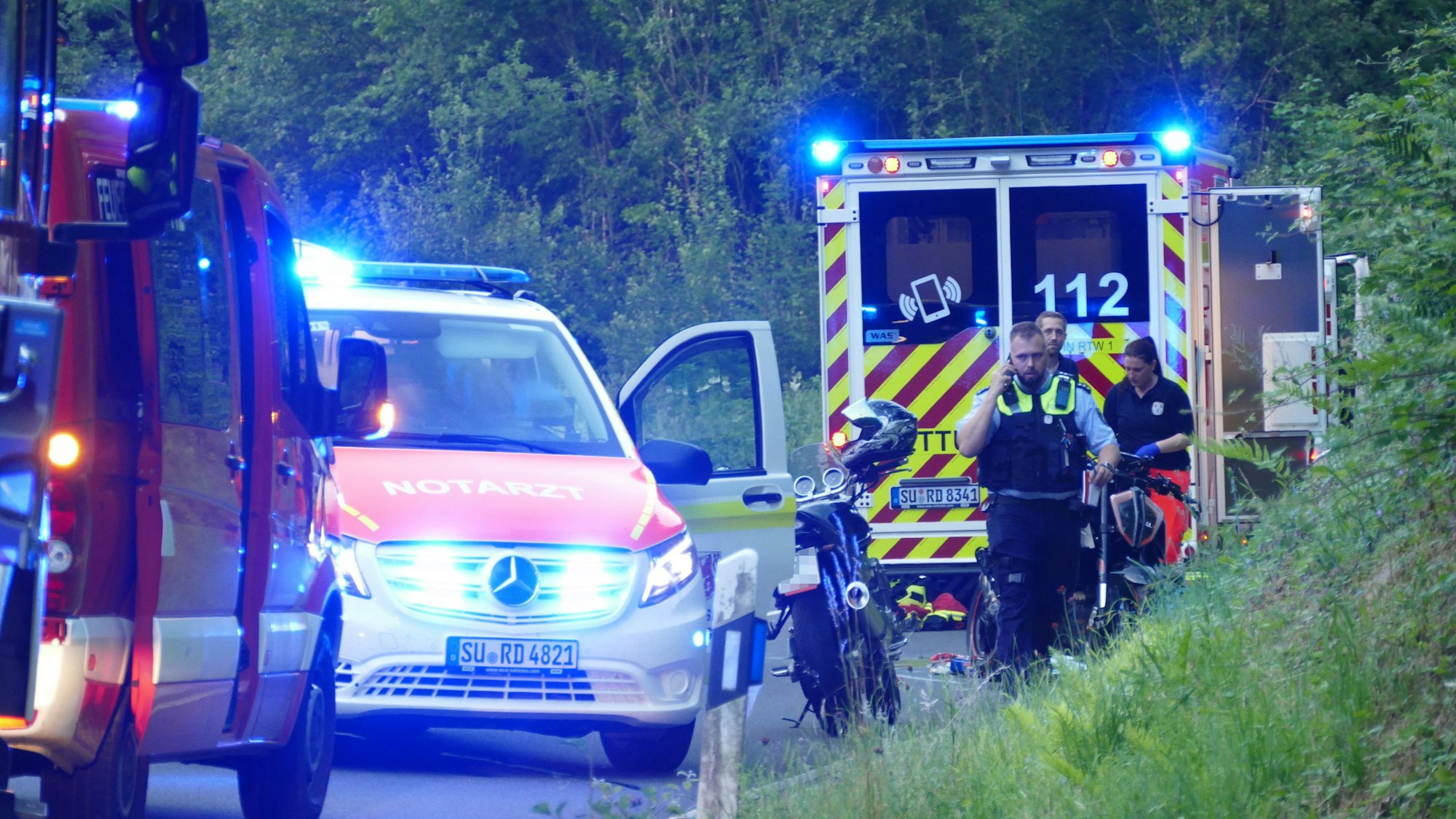 Polizeibeamte und Rettungskräfte stehen neben dem Motorrad des 24-Jährigen.