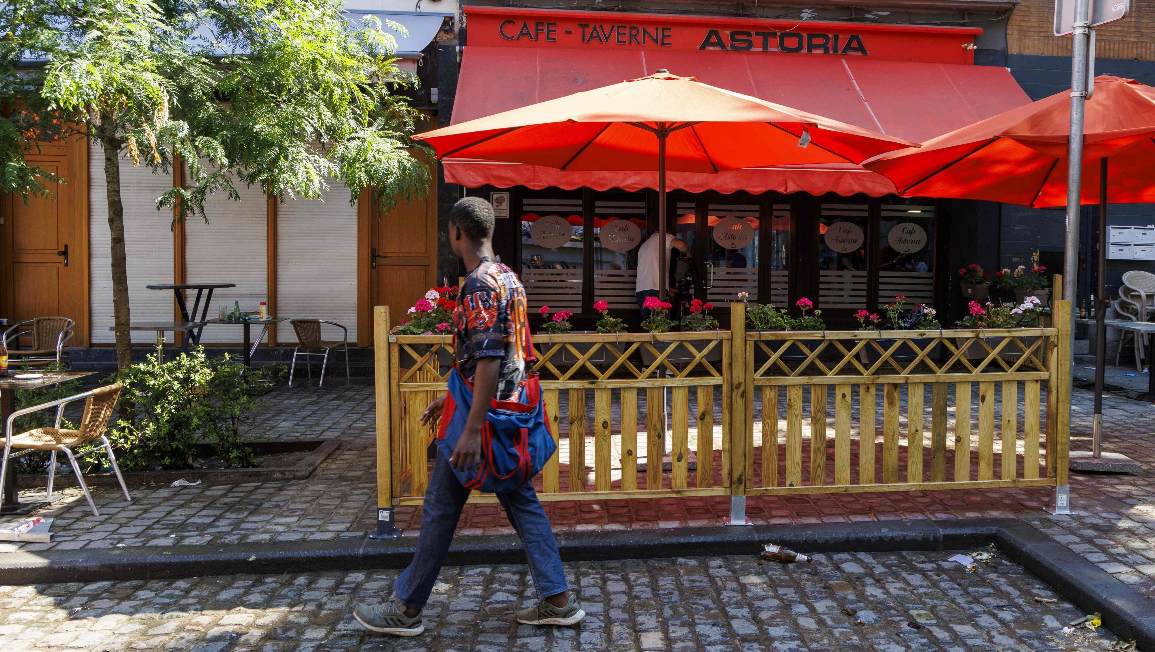 Diese Gesamtansicht zeigt einen Fußgänger, der am 27. Juni 2024 am Tatort einer Schießerei in einer Bar in Saint-Gilles, Brüssel, vorbeigeht. In der Bar in der Nähe des Bahnhofs Brüssel Midi wurden zwei Männer getötet und drei weitere schwer verletzt.
