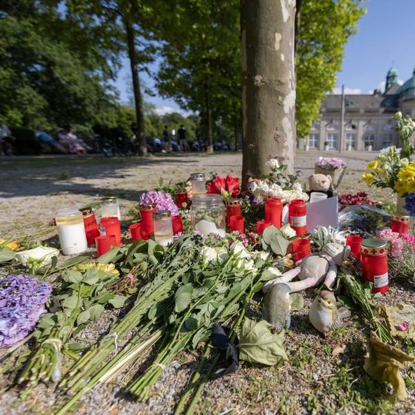 Blumen, Kerzen und handgeschriebene Trauerbekundungen stehen an einem Baum im Kurpark Bad Oeynhausen. Nach der tödlichen Attacke im Kurpark hatte die Polizei einen 18-jährigen Tatverdächtigen festgenommen.