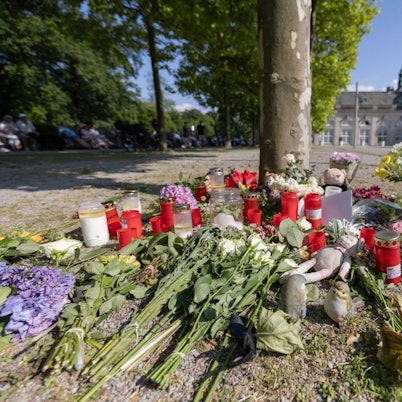 Blumen, Kerzen und handgeschriebene Trauerbekundungen stehen an einem Baum im Kurpark Bad Oeynhausen. Nach der tödlichen Attacke im Kurpark hatte die Polizei einen 18-jährigen Tatverdächtigen festgenommen.