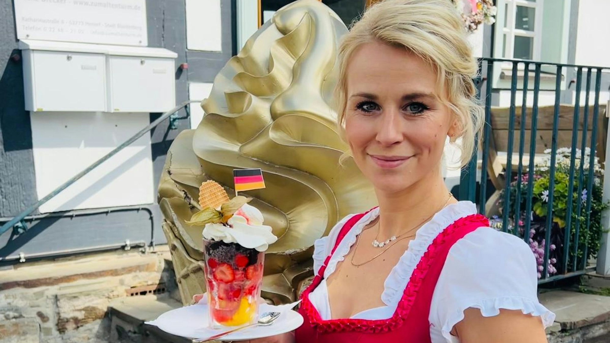 Laura Drecker präsentiert den EM-Eisbecher des Restaurants Zum Alten Turm in Stadt Blankenberg.