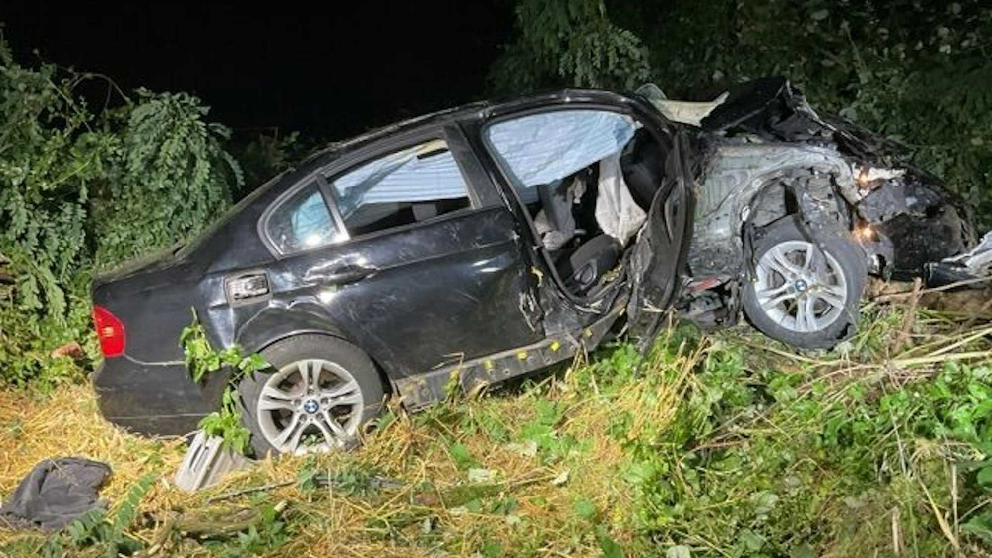 Ein schwarzer Pkw in einer Böschung.