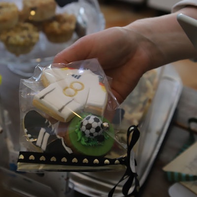 Ein Toni Kroos-Trikot, Fußballschuhe und ein Fußball auf einem Mini-Rasen werden in einer kleinen Tüte verkauft.