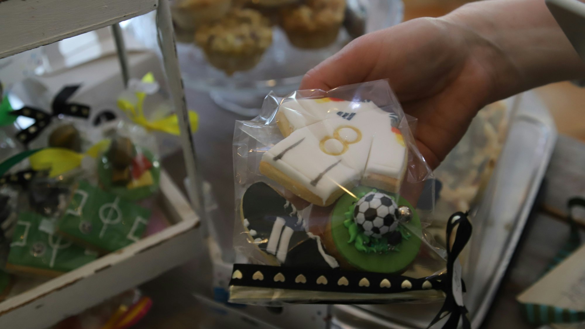 Ein Toni Kroos-Trikot, Fußballschuhe und ein Fußball auf einem Mini-Rasen werden in einer kleinen Tüte verkauft.