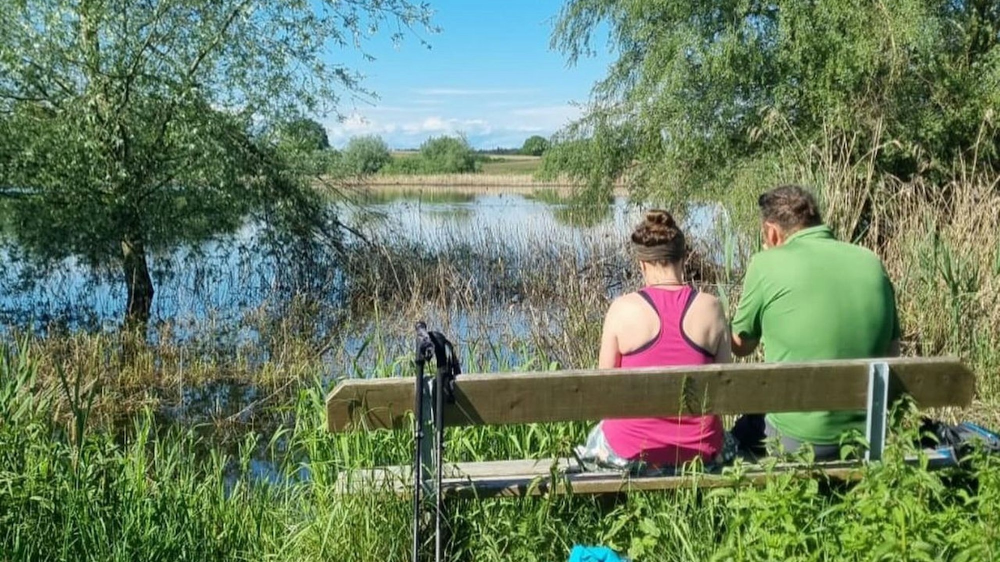 Bettina und Ralf Schaffrath sitzen auf einer Bank vor einem See.