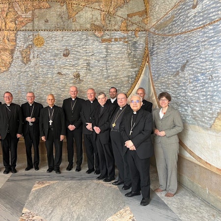 Teilnehmer eines Treffens von deutschen Bischöfen mit Vertretern der Römischen Kurie im Vatikan stehen zusammen. Der Vatikan will den Reformprozess in Deutschlands katholischer Kirche genau im Auge behalten.