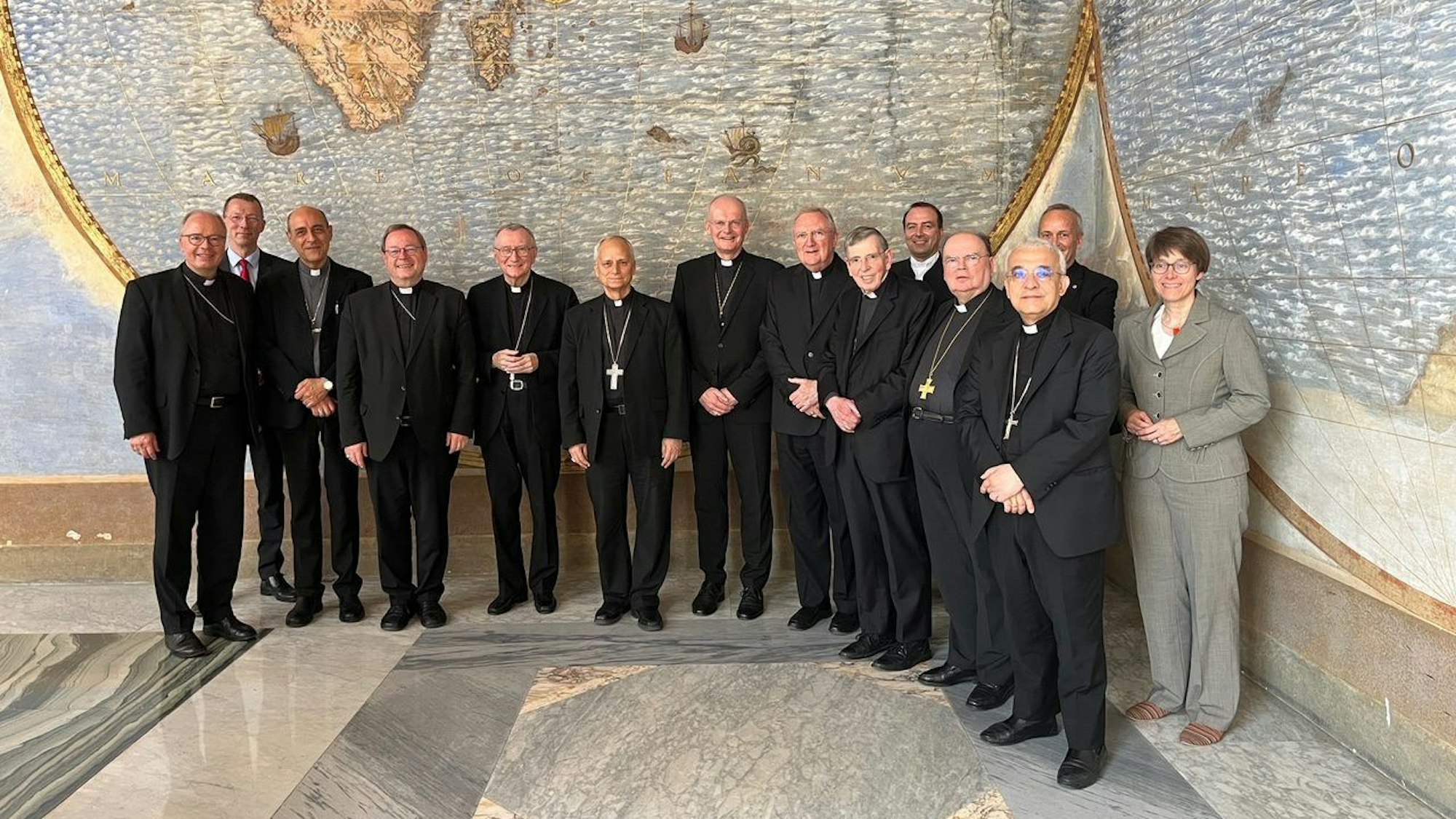 Teilnehmer eines Treffens von deutschen Bischöfen mit Vertretern der Römischen Kurie im Vatikan stehen zusammen. Der Vatikan will den Reformprozess in Deutschlands katholischer Kirche genau im Auge behalten.