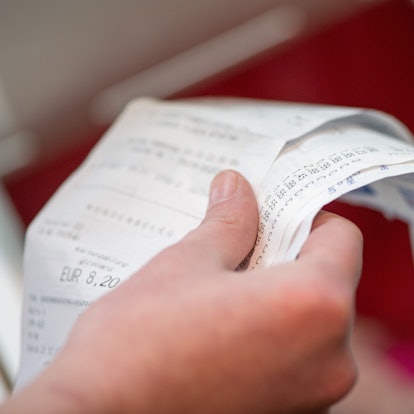 Eine Hand hält mehrere Kassenzettel.