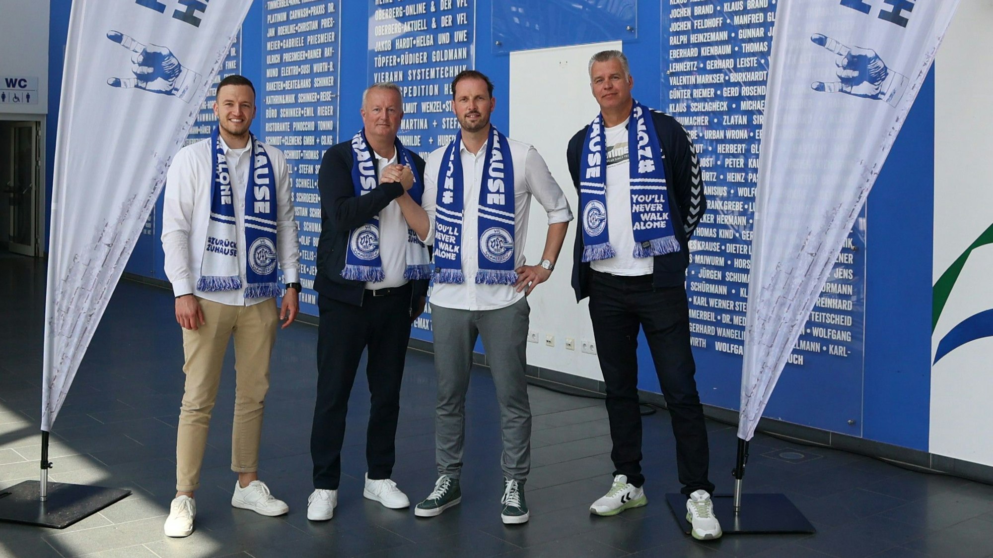 Zu sehen sind vier Männer mit Schals