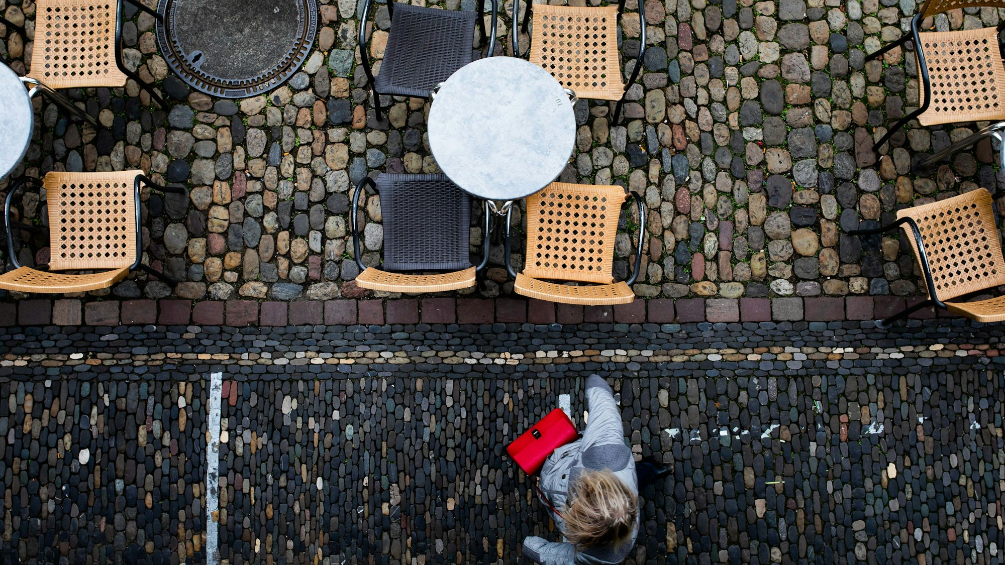 Leeren Tische und Stühle eines Eiscafés. Lockdowns haben unter anderem die Gastronomie in der Corona-Zeit getroffen.