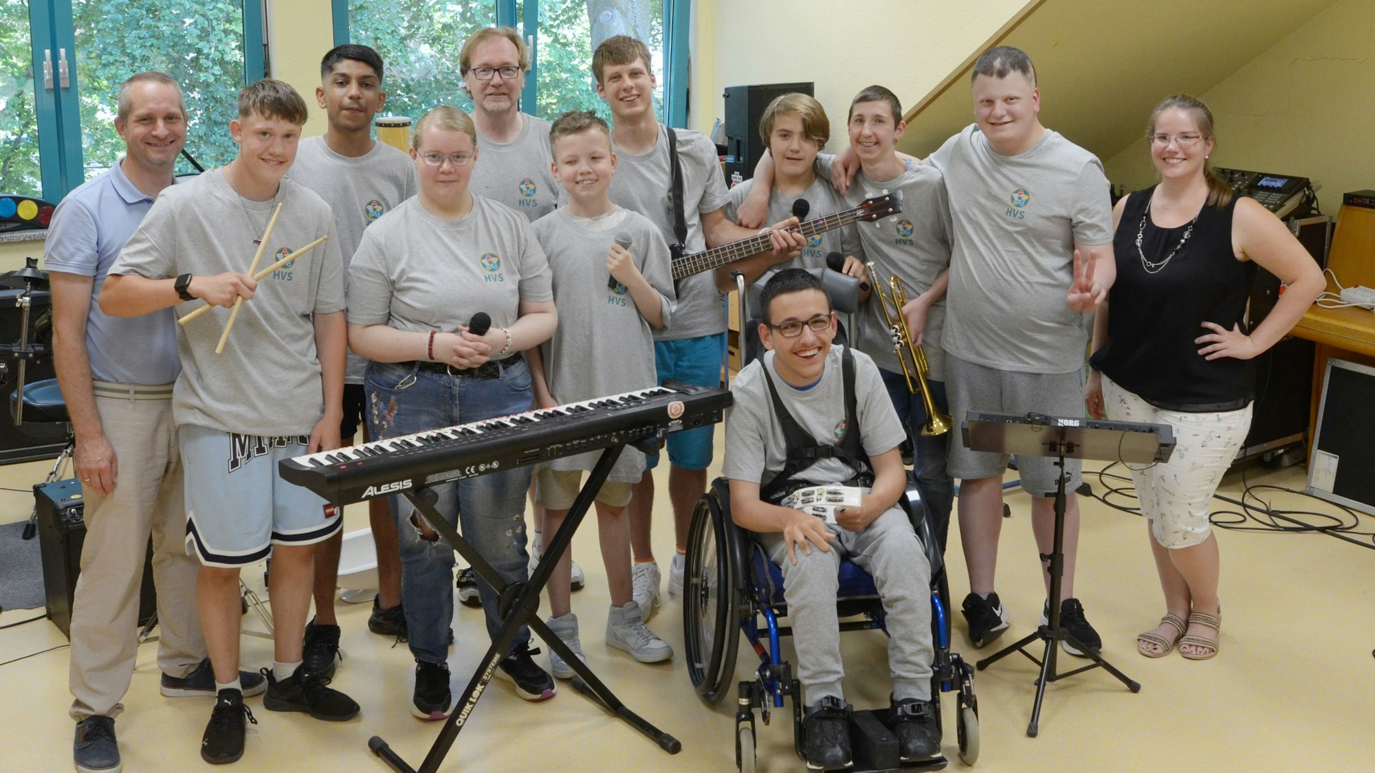 Die Musikerinnen und Musiker haben sich mit Lehrerin und Lehrern zum Gruppenbild aufgestellt.