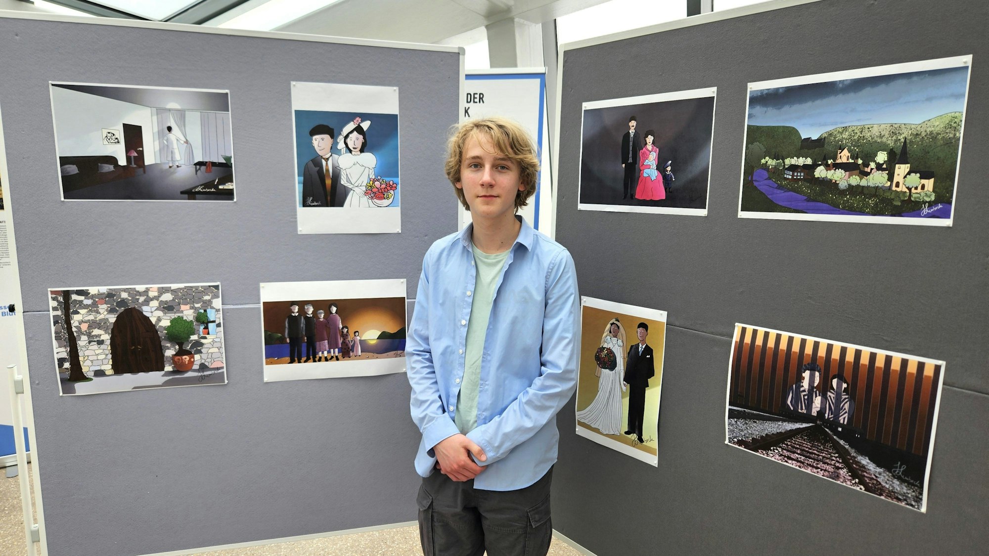 Hlynur Jakob Limbeck steht vor den Stellwänden, an denen seine Zeichnungen hängen.